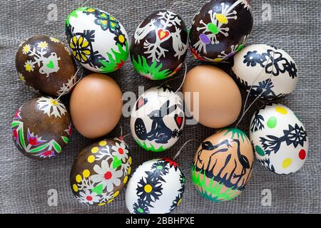 Uova di Pasqua dai colori moderni secondo la tradizione lituana su uno sfondo di tessuto di lino: Marrone naturale, tinto e decorato con figure Foto Stock