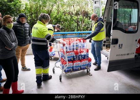 Consegna uomini off caricare l'acqua donata.'Federacion de Penas' di Mostoles dona 4000l di acqua minerale all'ospedale universitario di Mostoles per aiutare nella lotta contro la pandemia del virus corona. Foto Stock