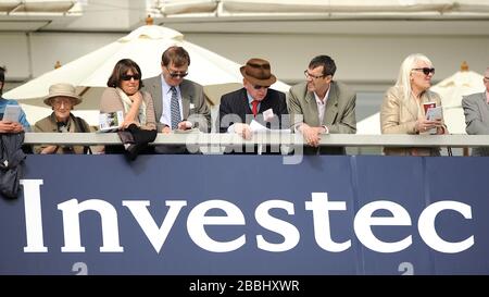 Racegoers goditi l'azione all'ippodromo di Epsom Downs Foto Stock