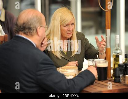 Racegoers goditi l'azione all'ippodromo di Epsom Downs Foto Stock