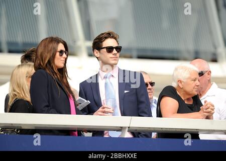 Racegatori guardare l'azione dal grandstand Foto Stock