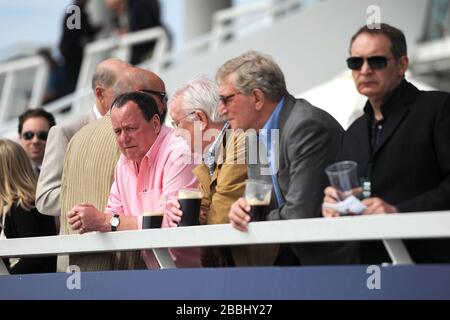 Racegoers goditi l'azione all'ippodromo di Epsom Downs Foto Stock
