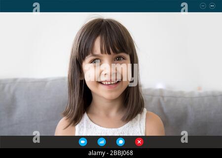 Sorridente ragazzina parla con i genitori durante una videochiamata Foto Stock