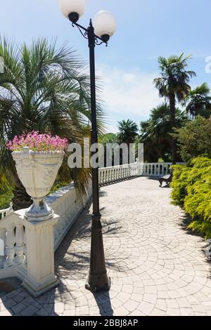 Ponte di osservazione piastrellato con panca nell'antico Parco. La balaustra è decorata con vasi di fiori. Yuzhnye Kultury Park Foto Stock