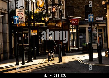 Ciclista solitaria a Covent Garden, Londra, Inghilterra durante lo scoppio del virus della corona. Foto Stock