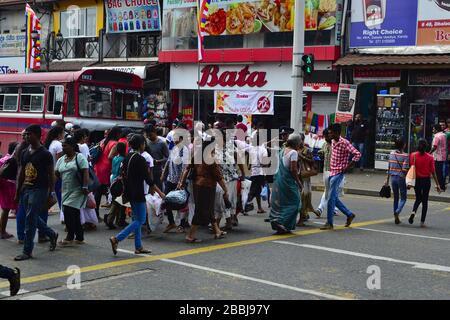 Kandy, Sri Lanka - aprile 2017: Folla di persone che attraversano l'incrocio stradale sulla strada pedonale prima dell'autobus sulla strada centrale chiamata Kandy Road. Foto Stock