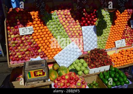 Mercato di strada con frutta colorata. Scatola di legno con bandiera dello Sri Lanka piccola. Piccola impresa per la vendita di alimenti sani. Kandy, Sri Lanka Foto Stock