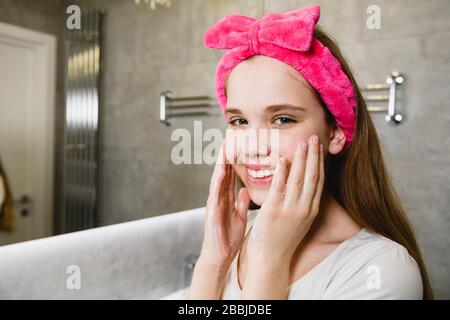 Ragazza teen lavare faccia con schiuma di sapone Foto Stock