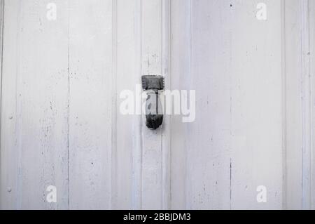 Maniglia della porta a forma di mano. Maniglia in una porta antica bianca Foto Stock