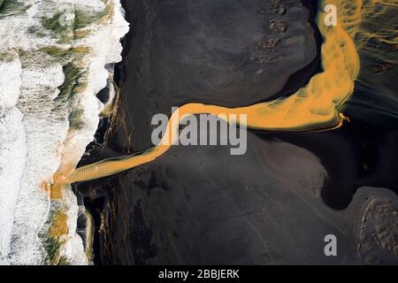 Vista aerea del fiume arancione intrecciato che scorre nell'oceano nel sud Foto Stock