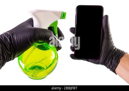Pulizia manuale di uno smartphone con un igienizzatore per bottiglie spray Foto Stock