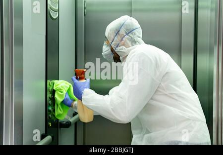 coronavirus. operaio che disinfetta l'ascensore dell'ospedale per evitare il contagio. Foto Stock