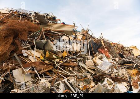 Una montagna enorme di pezzi di metallo di origine diversa accumulato in un cantiere di scarto Foto Stock