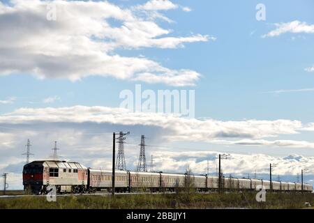 Un treno passeggeri vicino alla città di Novy Urengoy nel territorio autonomo di Yamalo-Nenetz, Russia settentrionale. La locomotiva è un motore diesel di classe TEP-70. Foto Stock