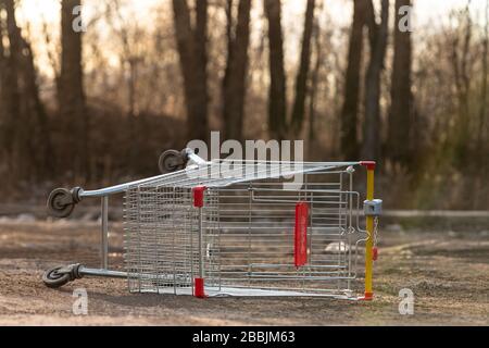 Carrello vuoto invertito sulla strada. Effetto pandemico del coronavirus - quarantena e isolamento della popolazione nelle città. Crisi, panico comprando f Foto Stock