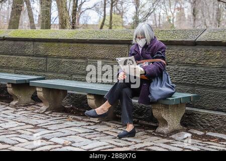 New York, NEW YORK, EUA. 31st Mar, 2020. Una donna che indossa una maschera medica è visto leggere una rivista nel Central Park durante il Covid-19 Coronavirus Pandemic negli Stati Uniti. Credit: Vanessa Carvalho/ZUMA Wire/Alamy Live News Foto Stock