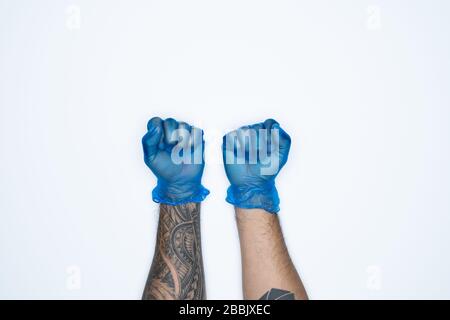 Le mani e i gesti di un uomo nel guanto in gomma blu mostrano il segno di spavento isolato su sfondo bianco. Foto Stock