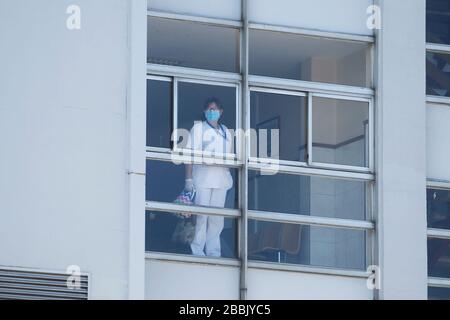 Gli operatori sanitari che si occupano della nuova crisi del coronavirus guardano attraverso le finestre dell'ospedale di Coruna, nella Spagna nordoccidentale, il 26 marzo 2020 Foto Stock