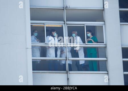 Gli operatori sanitari che si occupano della nuova crisi del coronavirus guardano attraverso le finestre dell'ospedale di Coruna, nella Spagna nordoccidentale, il 26 marzo 2020 Foto Stock
