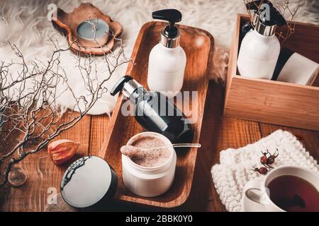 Bottiglie cosmetiche con cosmetici per la cura del corpo su un tavolo in legno. Spa su sfondo in legno. Foto Stock