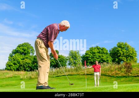 Giovane e vecchio che gioca a golf Foto Stock