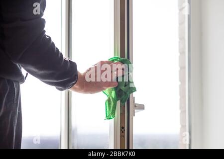 Pulizia finestre con straccio speciale e detergente, mani maschio lava vetro finestra in casa appartamento. Pulizia finestre.pulizia casa. Lavaggio della finestra sporca Foto Stock