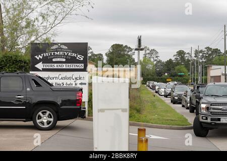 Houston, Texas - 31 marzo 2020: Le auto aspettano in fila per entrare nel parcheggio di Whitmeyer per la loro igienizzazione gratuita delle mani. Foto Stock