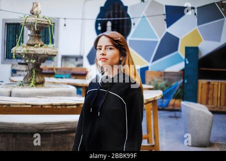 Seria ragazza latina che ascolta musica in cuffie in città del Messico Foto Stock