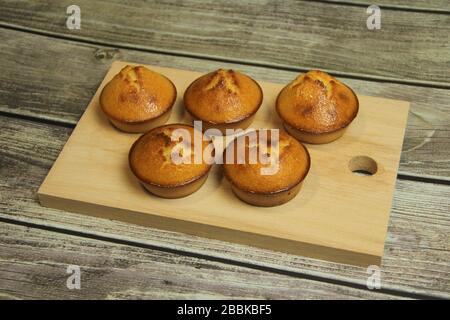 Cinque torte dorate su una tavola di legno su un tavolo di legno da tavole. Foto Stock