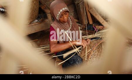 Craftswoman cesto di bambù mentre fa il suo lavoro in un posto Foto Stock