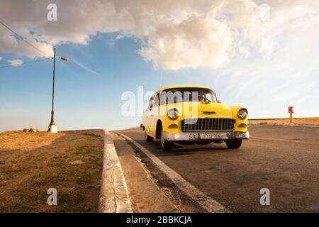 HAVANA, CUBA - 31 MARZO 2017: Auto americana vecchia e arrugginita gialla che guida su un'autostrada Havana. Cuba Foto Stock