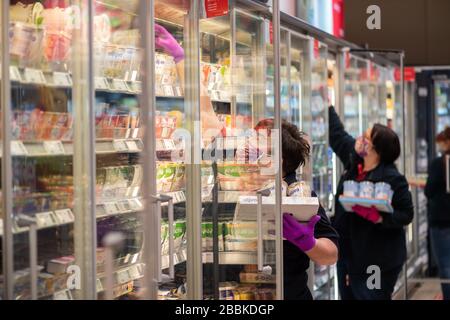 Dresda, Germania. 01st Apr, 2020. I dipendenti di un supermercato indossano maschere protettive mentre immagazzinano gli scaffali con merci prima che il negozio si apra. Per rallentare la diffusione del coronavirus, il governo federale ha ulteriormente limitato gravemente la vita pubblica. Credito: Robert Michael/dpa-Zentralbild/dpa/Alamy Live News Foto Stock