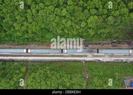 (200401) -- YONGXING, 1 aprile 2020 (Xinhua) -- Foto aerea scattata il 1 aprile 2020 mostra un treno che passa attraverso il sito degli incidenti sulla linea ferroviaria Pechino-Guangzhou nella città di Chenzhou, nella provincia centrale della Cina Hunan. Il traffico ferroviario è ripreso mercoledì nella città di Chenzhou, nella provincia di Hunan, nel centro della Cina, dopo un viaggio in treno di lunedì. Un treno da Pechino alla città turistica della Cina del sud di Sanya è andato attraverso il luogo dell'incidente sulla linea ferroviaria di Pechino-Guangzhou intorno alle 11:45 di mattina Mercoledì. È stato il primo treno a passare il sito dopo l'incidente che ha ucciso uno e ferito 127. (Xin Foto Stock