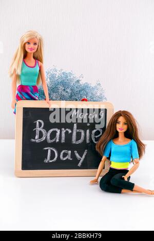 Tambov, Federazione russa - 24 febbraio 2020 due bambole Barbie vicino a una lavagna con parole Barbie Day marzo 9th. Studio. Foto Stock