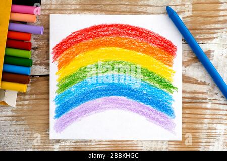 Disegno a mano Arcobaleno con pastelli di cera. Sfondo in legno. Foto Stock