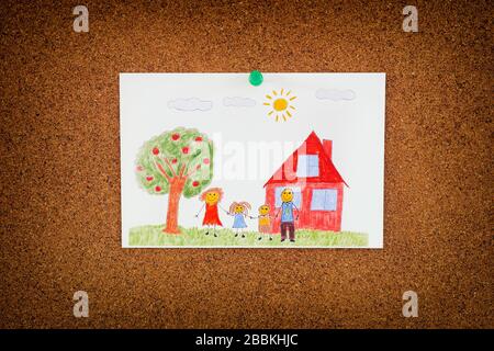 Disegno di una famiglia felice e un albero di mele e una casa inchiodati su tavola di sughero. Primo piano. Foto Stock