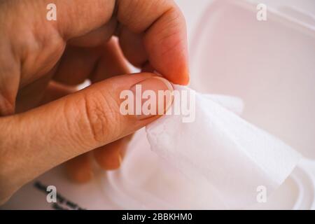 Donna mano che prende wet wipe dalla confezione. Primo piano. Foto Stock