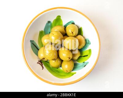 Una ciotola di olive verdi snocciolate su una tovaglia bianca Foto Stock