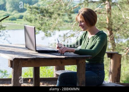 Bella ragazza che usa il suo tablet grafico all'aperto Foto Stock