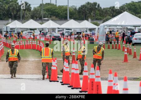 I soldati della Guardia Nazionale della Florida monitorano il traffico mentre le persone entrano nel sito di test drive-through presso il FITEAM Ballpark delle spiagge di Palm in mezzo alla pandemia globale di coronavirus COVID-19, martedì 31 marzo 2020, a West Palm Beach, Fl. oltre 250 persone sono state testate durante il primo giorno del test sponsorizzato dal governo. ((Foto di IOS/Espa-immagini) Foto Stock