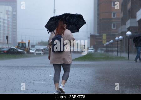 San Pietroburgo, Russia Giugno 2019-murino district, heavy rain, inondazioni, la gente a piedi sotto la pioggia con ombrelloni. Foto Stock