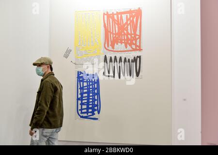 Un visitatore della mostra ARCO 2020 di Madrid indossa una maschera facciale. Foto Stock
