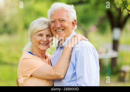 Sorridendo felice anziani anziani coppia nel parco Foto Stock