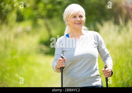 Senior donna esercita in posizione di parcheggio Foto Stock
