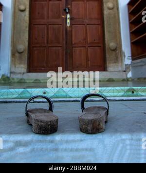 Zoccoli di fronte alla porta della moschea Foto Stock