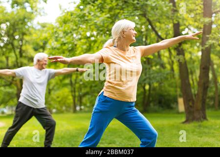 Coppia senior che esercitano in posizione di parcheggio Foto Stock