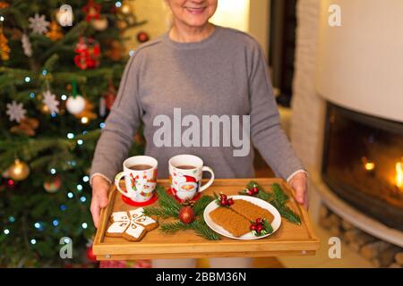 Senior donna tenendo il vassoio di biscotti di Natale Foto Stock