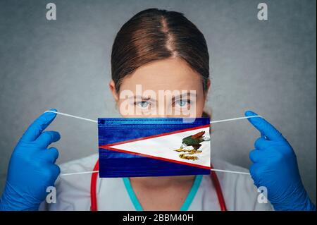 Coronavirus nelle Samoa Americane, Ritratto medico femminile, Proteggi la maschera medica chirurgica del viso con la bandiera Samoa Americane. Malattia, virus Covid-19 Foto Stock