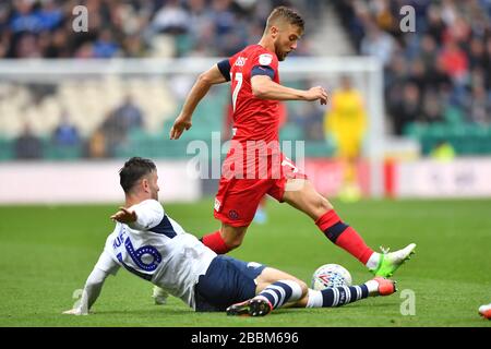 Michael Jacobs di Wigan Athletic è affrontato da Andrew Hughes di Preston North End Foto Stock