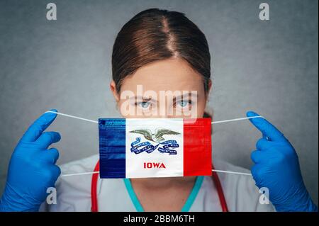 Coronavirus negli Stati Uniti Iowa, femmina Doctor Portrait, proteggere maschera medica chirurgica viso con Iowa Flag. Malattia, virus Covid-19 in Iowa Foto Stock